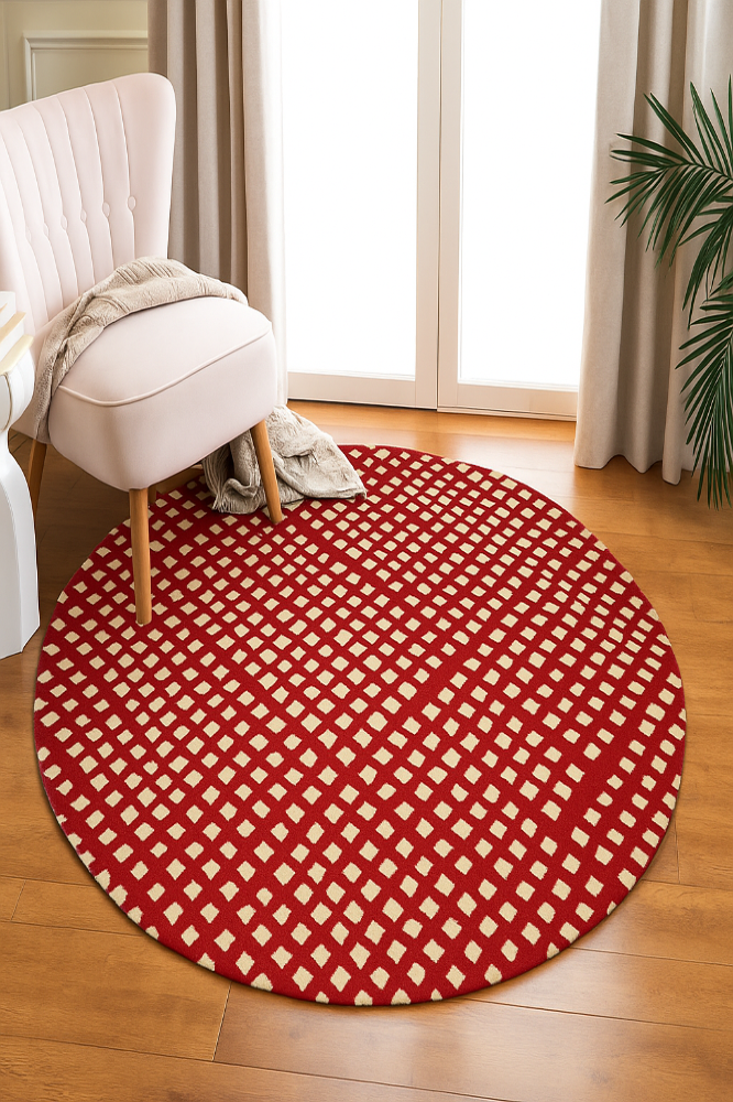 Round red and white checkered rug on a wooden floor with a chair and plant in the background.