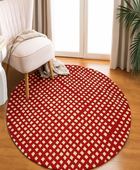 Round red and white checkered rug on a wooden floor with a chair and plant in the background.