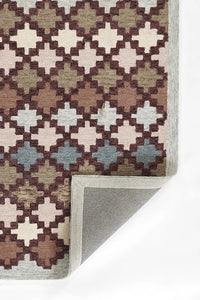Geometric patterned rug corner on a white background